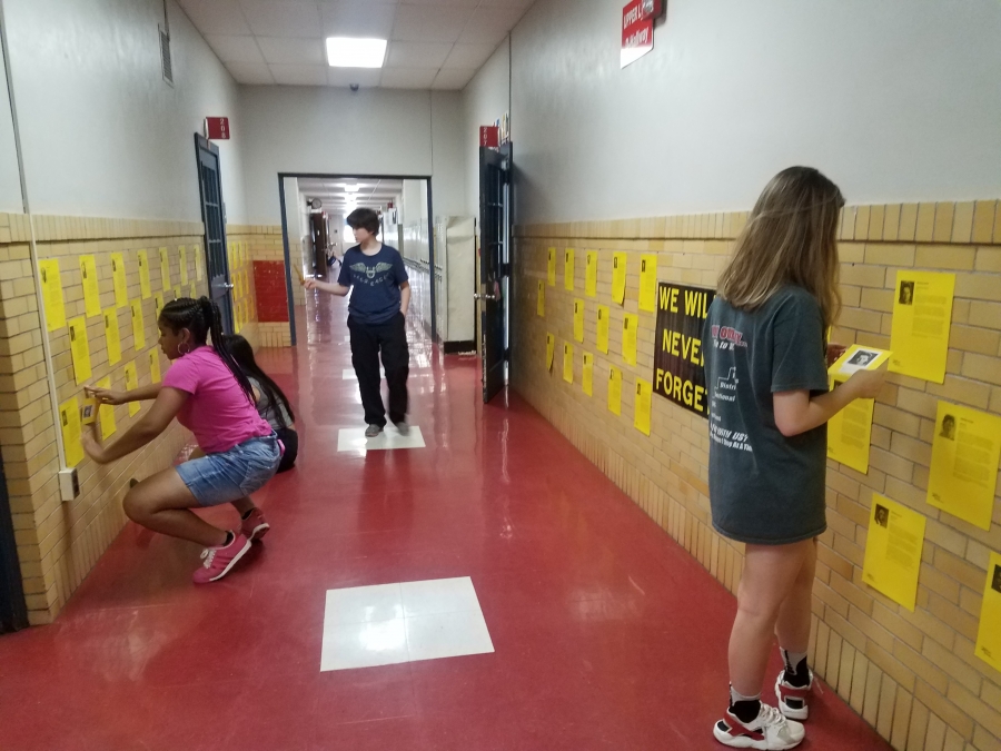 Students review posters in hallway