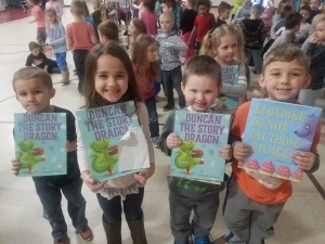 kids holding their books to be autographed