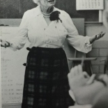 Photo of Ione Holt standing in the front of a classroom.