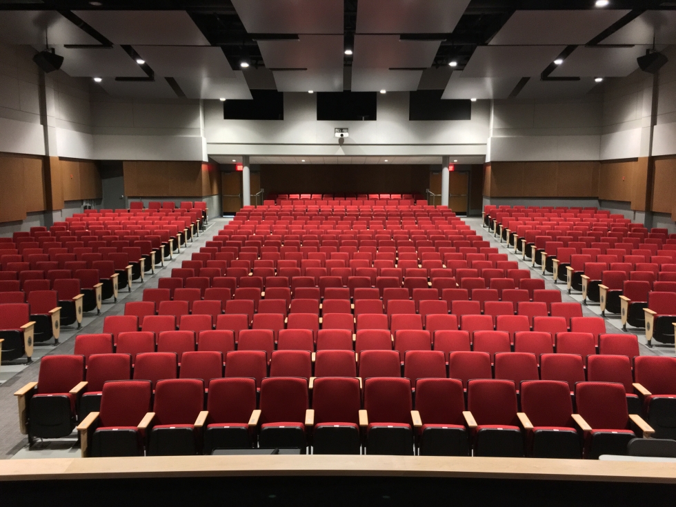 Photo of the renovated auditorium at Oak Hills High School now from the stage looking at the red seats
