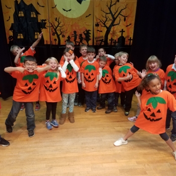 students dressed as jackolanterns for Halloween show