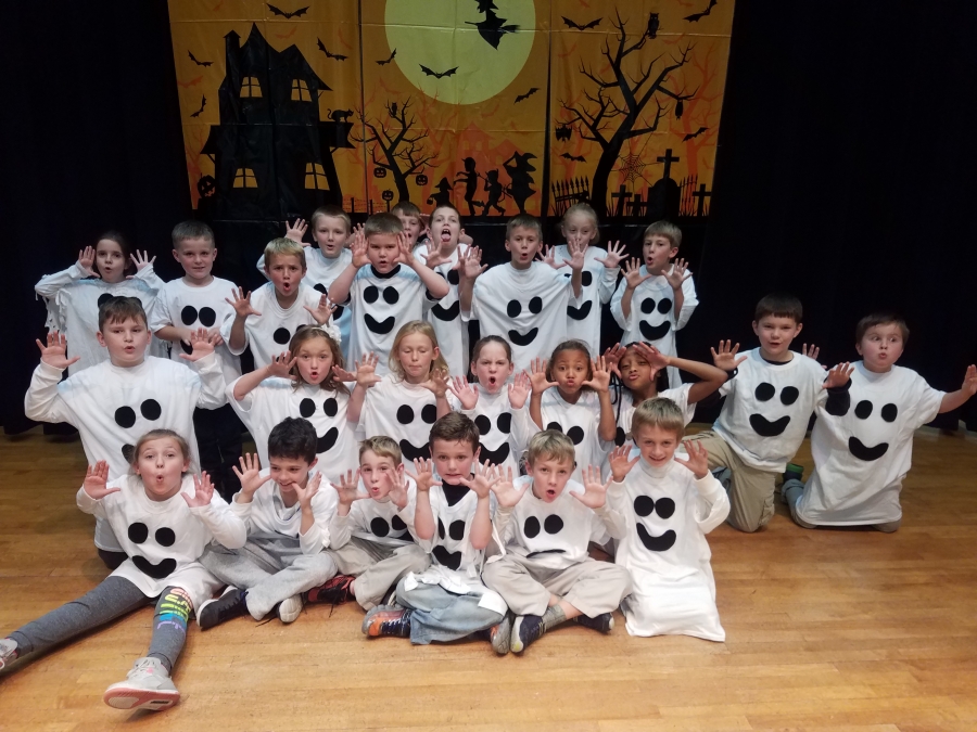 second graders dressed as ghosts for Halloween production